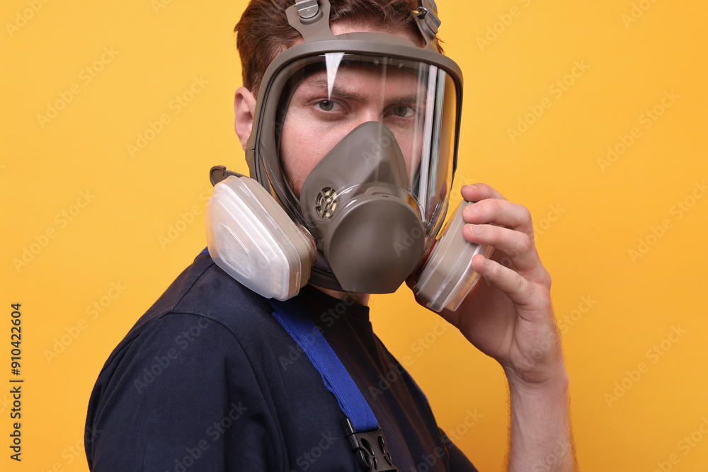 Man in respirator mask on yellow background Man in respirator mask on yellow background