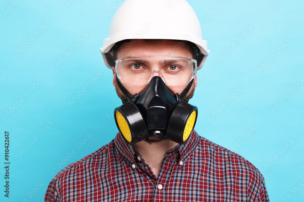 Man in respirator mask and hard hat on light blue background Man in respirator mask and hard hat on light blue background