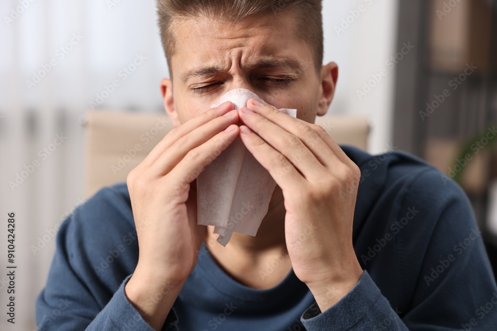 Young man with tissue suffering from sinusitis indoors Young man with tissue suffering from sinusitis indoors