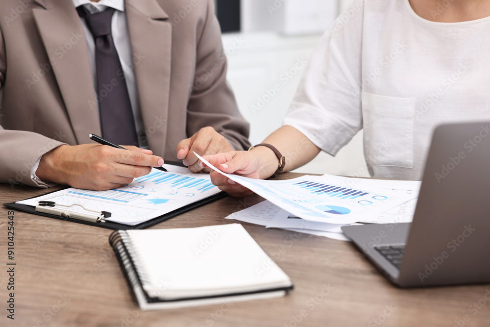 Consultant working with client at wooden table in office, closeup. Business meeting Consultant working with client at wooden table in office, closeup. Business meeting