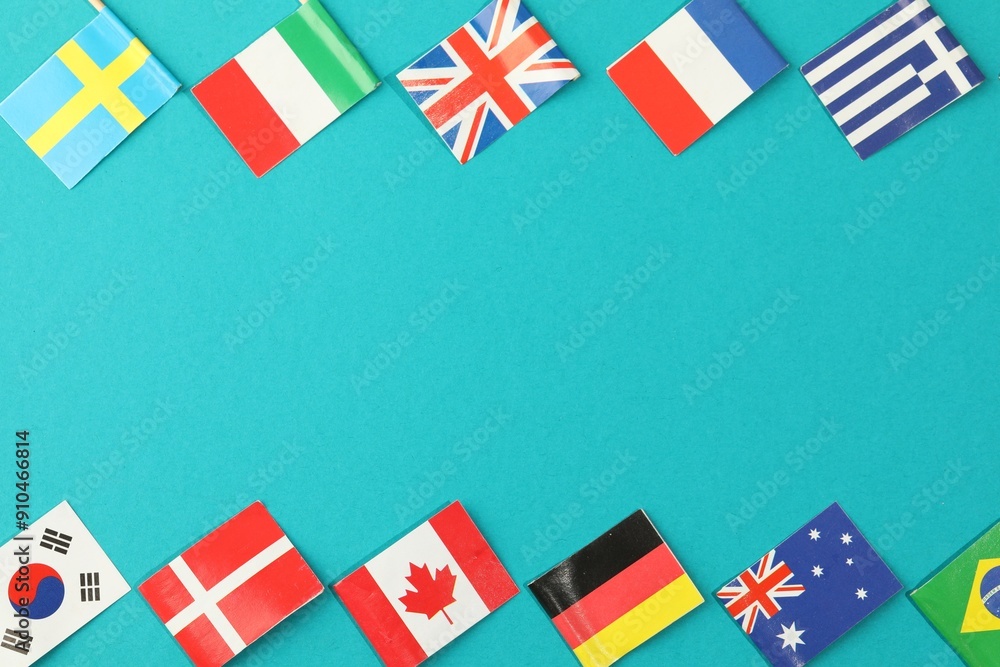 Obraz premium Small paper flags of different countries on light blue background, flat lay. Space for text