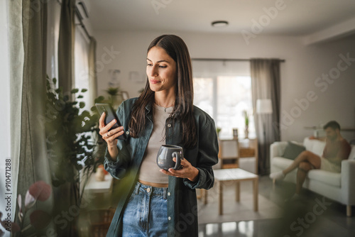 Photography Portrait of adult young woman stand hold cup and use mobile phone