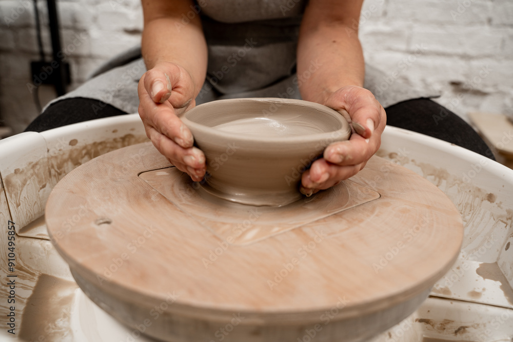 Creating a ceramic bowl by yourself in a pottery class. Wheel throwing. Learning how to model clay into different shapes with pottery wheel. Creating a ceramic bowl by yourself in a pottery class. Wheel throwing. Learning how to model clay into different shapes with pottery wheel.