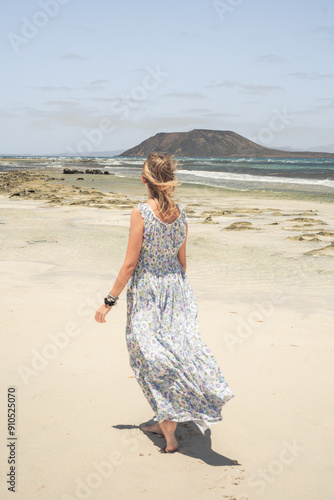 Chica rubia caminando por la playa disfrutando el verano en las islas canarias, Fuerteventura