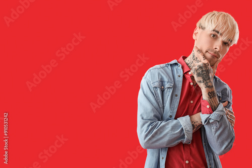 Tattooed young man on red b...