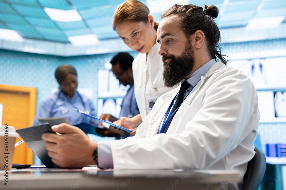 Fototapeta premium Doctors team working in a medical treatment center to find diagnosis. Professional experts engaged in a meeting about checkup test results in a private clinic, healthcare industry teamwork.