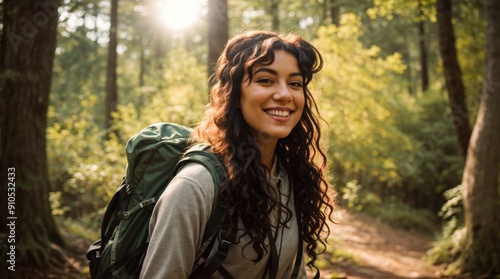 Satisfied woman with a backpack takes joy in a sunny forest outing 