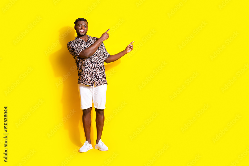 Photo of nice cheerful glad man wear trendy clothes presenting empty space isolated on vivid yellow color background Photo of nice cheerful glad man wear trendy clothes presenting empty space isolated on vivid yellow color background