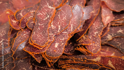 Dried meat slices, showcasing their intricate patterns and textures. The natural colors of dark brown to red blend seamlessly with orange veins