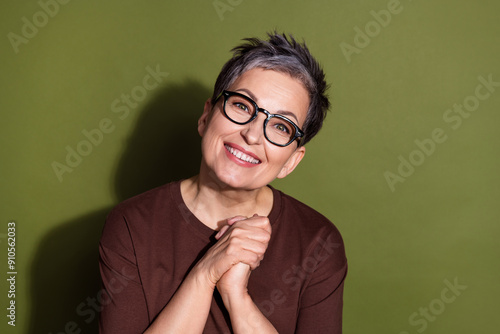 Photo portrait of gray hair beautiful grandmother very lovely model in brown t shirt and eyeglasses hands together isolated on khaki color background