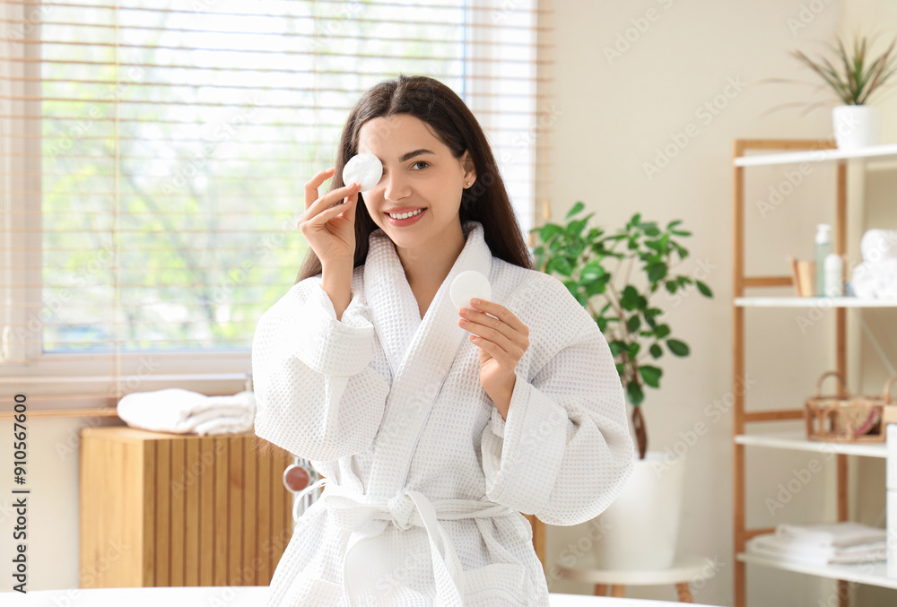 Beautiful young happy woman in bathrobe with cotton pads for removing makeup at home Beautiful young happy woman in bathrobe with cotton pads for removing makeup at home