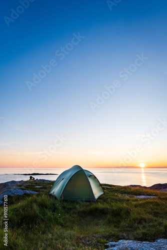 Camping in tent with Midnight sun and sea in Norway over the sea in Andoya, Nordland, Norway photo