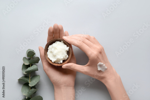 Female hands with bowl of shea butter on white background photo