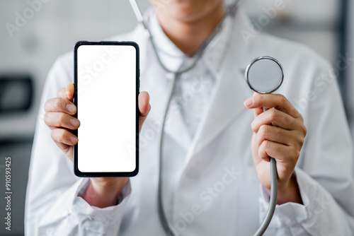 Medical professional in white coat holding a smartphone with blank screen and stethoscope, representing modern healthcare technology. photo