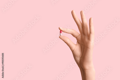 Female hand holding pill on...