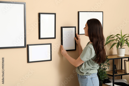 Young woman hanging blank p...