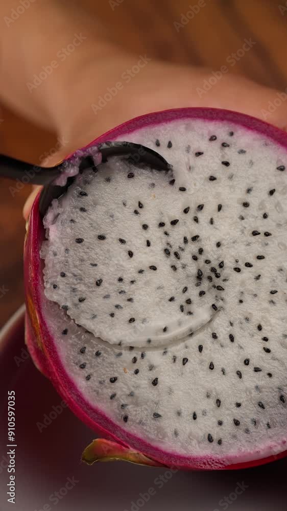 Vertical video, A Latin woman s hands scooping the pulp of a dragon fruit with a spoon Vertical video, A Latin woman s hands scooping the pulp of a dragon fruit with a spoon