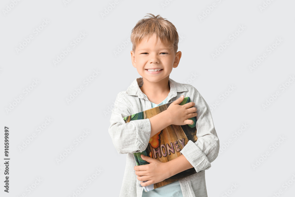 Cute little boy with book on grey background Cute little boy with book on grey background