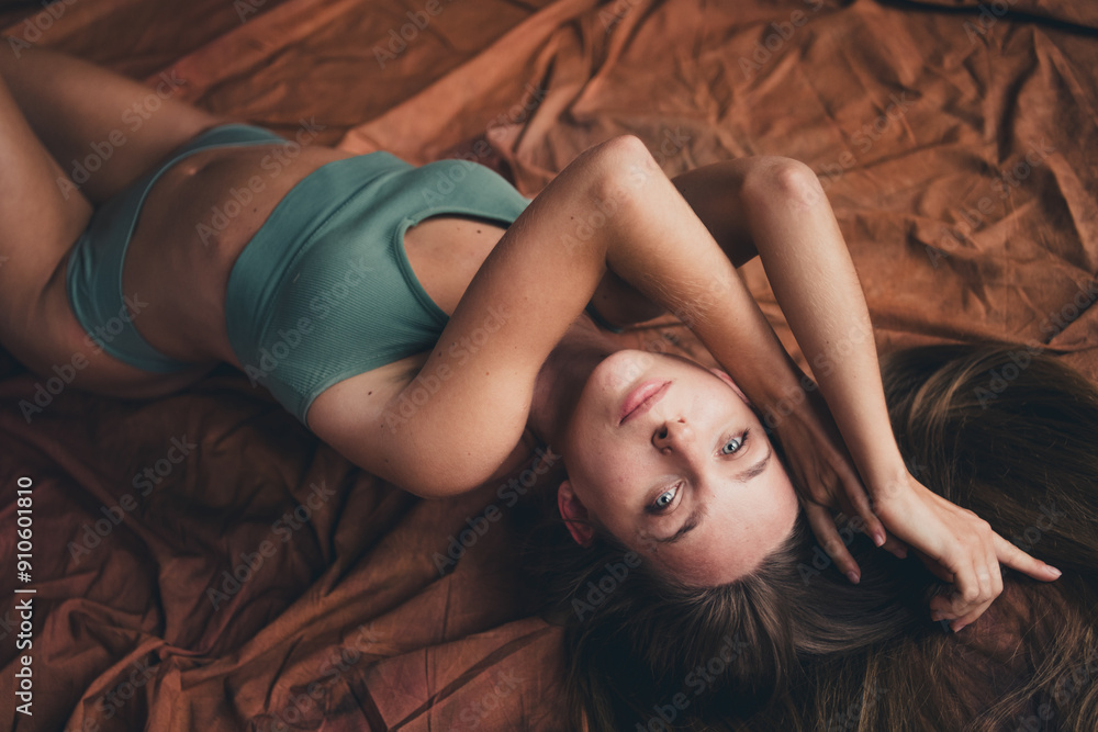 Close up no retouch photo of sweet tender girlfriend with imperfections lying in underwear isolated on brown color fabric background Close up no retouch photo of sweet tender girlfriend with imperfections lying in underwear isolated on brown color fabric background