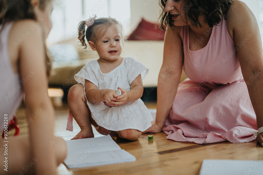 Mother and daughters enjoying quality time with a drawing activity at home. Warm family moments captured indoors. Mother and daughters enjoying quality time with a drawing activity at home. Warm family moments captured indoors.