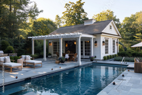 Classic pool house with open-air lounge, lush greenery, and sparkling pool behind a large white farmhouse in New England, mid-summer, captured with Canon EOS R5.