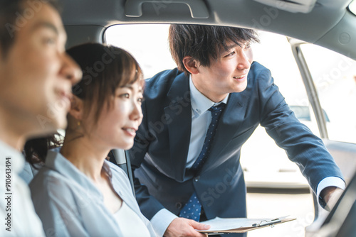 自動車購入・査定・買取にきた顧客を接客するセールスマンの若いアジア人男性
 photo