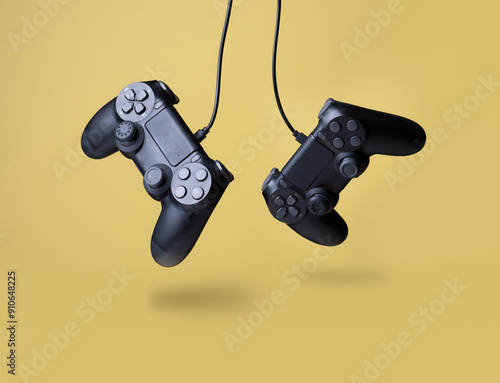 Flying air gamepads from a game console on a yellow background. The concept of games