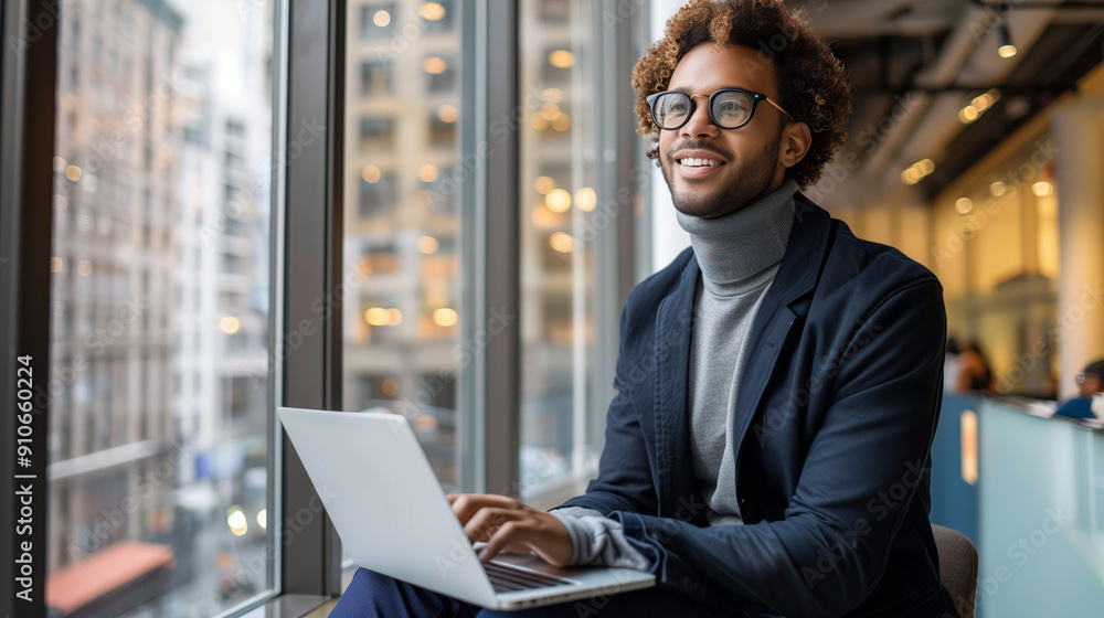 Happy businessman sitting at his desk laughing while working on his laptop in the office Happy businessman sitting at his desk laughing while working on his laptop in the office