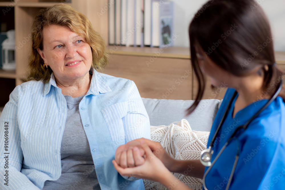 Obraz premium Caregiver young nurse woman examining elderly while holding arm for pulse sitting on sofa in living room at home, nurse checkup patient about cardiac, patient and insurance, medical and health.
