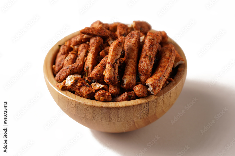 Fototapeta premium A bowl of Basreng (fried meatballs), a popular Indonesian snack made from thinly sliced fish meatballs, fried until crispy, and coated with spicy seasoning. Photographed against a white background.