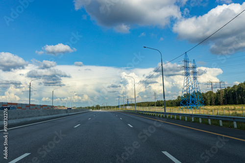 A blue sky with a few clouds and a road with a few cars