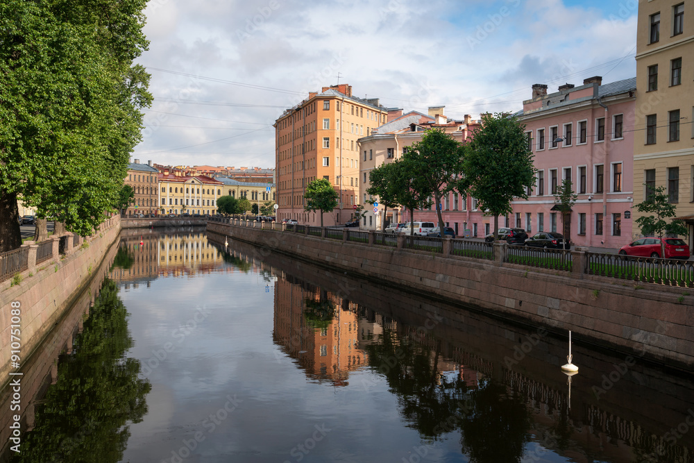 Fototapeta premium View of a residential building in the shape of an iron on the embankment of the Griboyedov Canal on a sunny day, St. Petersburg, Russia