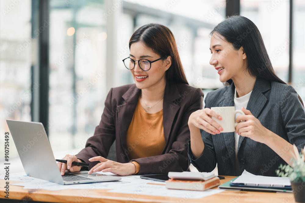 Two young Asian businesswomen discuss new startup project idea presentation, analyzing planning, financial statistics, and investment market at office. Two young Asian businesswomen discuss new startup project idea presentation, analyzing planning, financial statistics, and investment market at office.
