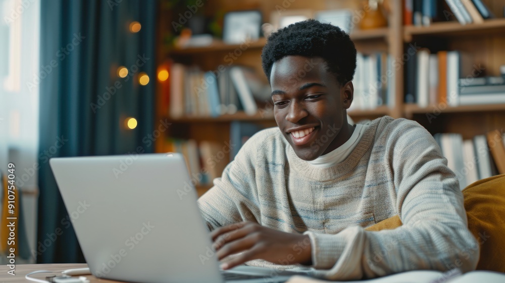 black boy using a laptop computer at home. A teenage boy attending to online school class on a laptop computer remote education. smiling teenager doing homework and studying. using modern technology. black boy using a laptop computer at home. A teenage boy attending to online school class on a laptop computer remote education. smiling teenager doing homework and studying. using modern technology.