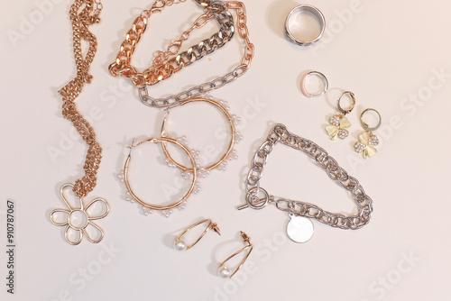 Gold and silver jewellery. Pastel Background