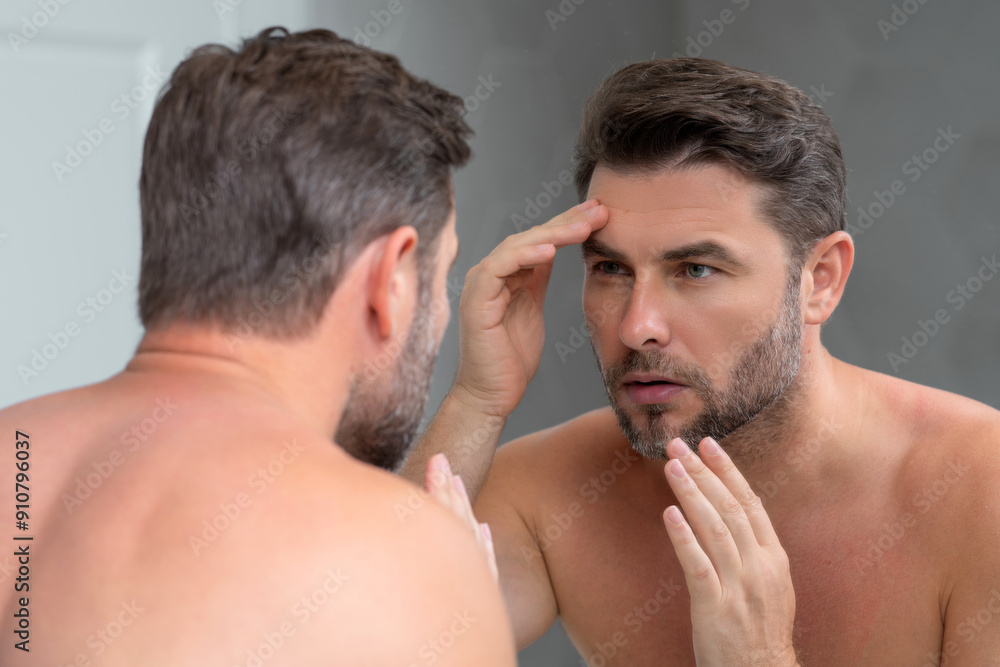 Fototapeta premium Mens beauty. Cream treatment for mens face. Beauty routine. Face of a beauty man with perfect skin. Anti-aging and wrinkle cream. Concept of male beauty. Male skincare cosmetics concept. Skin care.