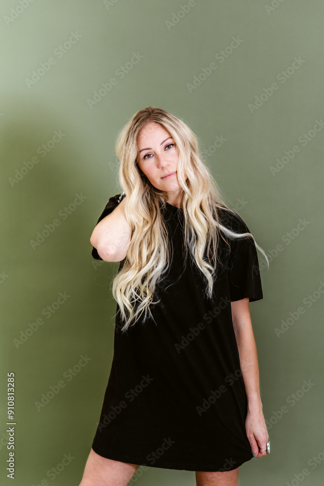 Fashionable blonde woman in a black t-shirt dress posing against Fashionable blonde woman in a black t-shirt dress posing against
