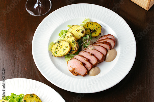 grilled beef tenderloin in a plate with sauce and side dish