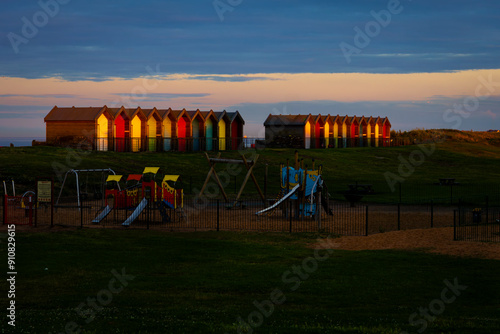 Beach huts at sunset with childrens play ground,  photo