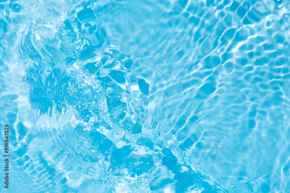 Obraz premium Blue water with ripples on the surface. Defocus blurred transparent blue colored clear calm water surface texture with splashes and bubbles. Water waves with shining pattern texture background.