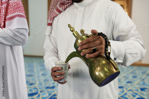 Valokuva Arab man holding Dallah and pours Arabic coffee to guests