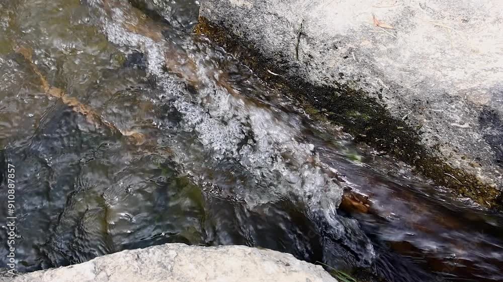 A stream flowing between stones. slow motion A stream flowing between stones. slow motion