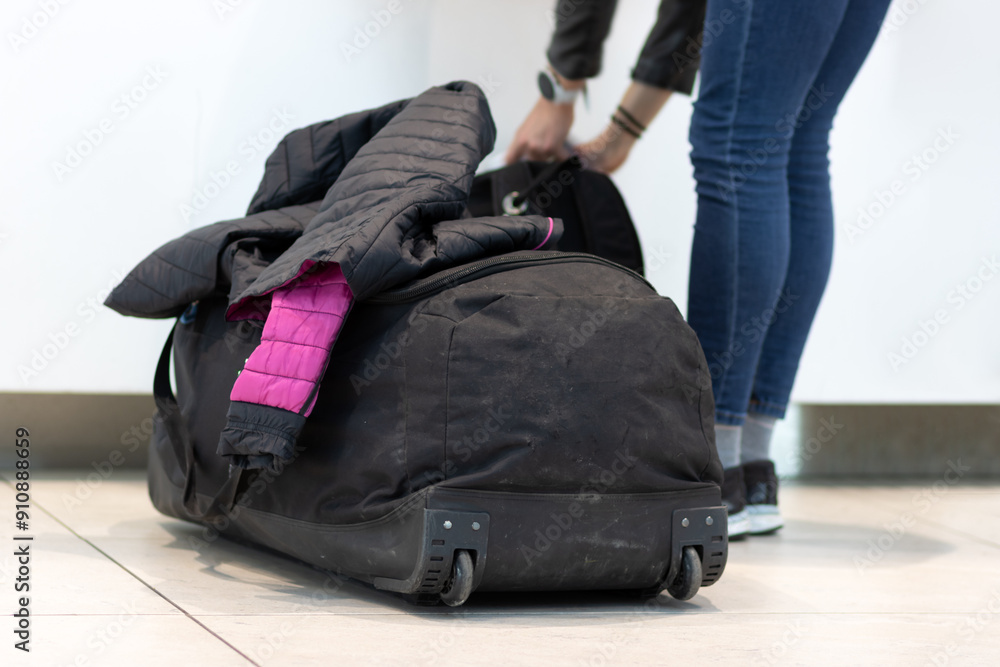 A passenger manipulate his luggage at the airport A passenger manipulate his luggage at the airport