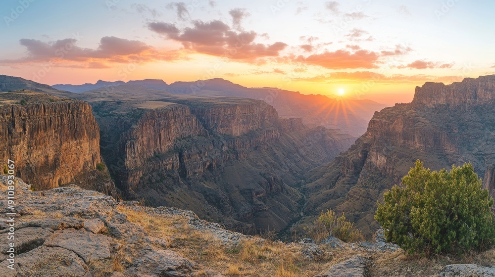 Panoramic View of Rugged Mountain Landscape at Sunset, Dramatic Cliffs and Deep Gorges with Sky Ablaze in Warm Hues of Orange and Pink Panoramic View of Rugged Mountain Landscape at Sunset, Dramatic Cliffs and Deep Gorges with Sky Ablaze in Warm Hues of Orange and Pink