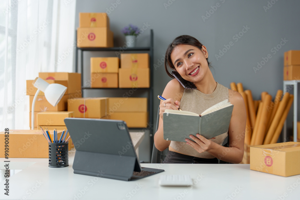 Asian Small business entrepreneur SME working with box and On the phone to confirm orders with customers at home, SME e-commerce digital technology concept. Asian Small business entrepreneur SME working with box and On the phone to confirm orders with customers at home, SME e-commerce digital technology concept.