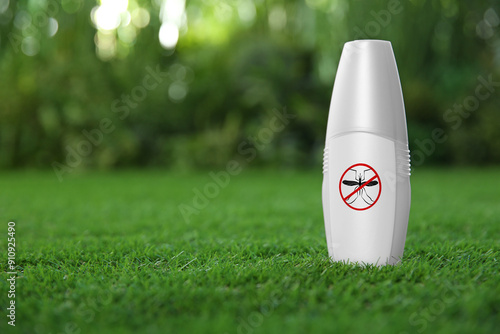 Mosquito spray on green grass outdoors, space for text. Insect repellent photo