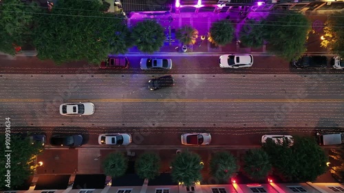 Traffic on party street in downtown of Fort Lauderdale, Florida. Night scene with blinking lights of Clubs and restaurant. Chain of lights decorating road. Aerial top down flyover. USA. photo