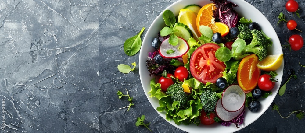 A nutritious salad in a bowl filled with fresh vegetables and fruits displayed with a copy space image A nutritious salad in a bowl filled with fresh vegetables and fruits displayed with a copy space image