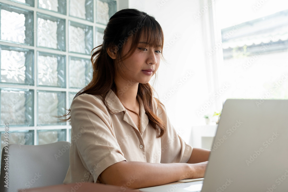 Young woman engages in online study at workspace. Young woman engages in online study at workspace.