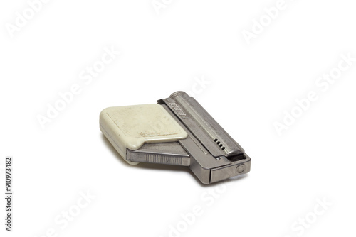 vintage petrol lighter in pistol style design. ajar, handle with plastic linings. isolated on white background, with clipping path